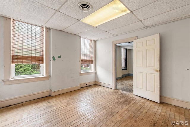 3456 Miami St, Saint Louis, MO 63118 - unfurnished room with wood-type flooring, plenty of natural light, baseboards, and a paneled ceiling