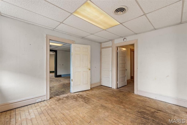 3456 Miami St, Saint Louis, MO 63118 - unfurnished bedroom with a drop ceiling, baseboards, and wood finished floors