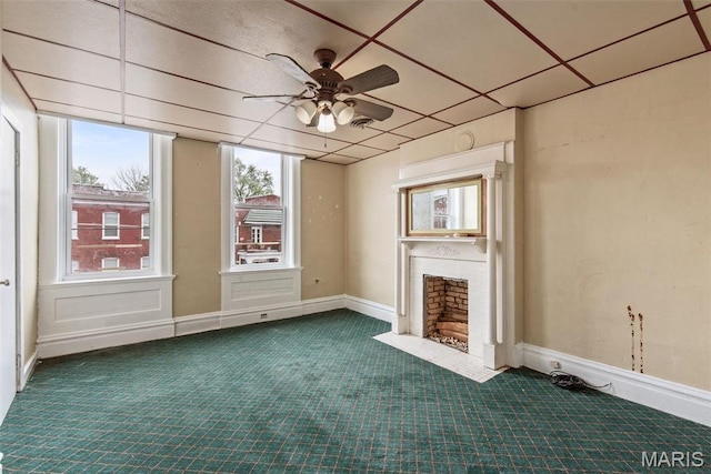 3456 Miami St, Saint Louis, MO 63118 - unfurnished living room with dark colored carpet, ceiling fan, and a fireplace with flush hearth