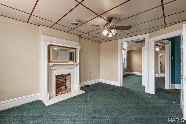 3456 Miami St, Saint Louis, MO 63118 - unfurnished living room featuring ceiling fan, carpet flooring, a fireplace, baseboards, and a drop ceiling