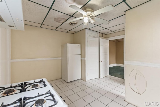 3456 Miami St, Saint Louis, MO 63118 - kitchen featuring freestanding refrigerator, a drop ceiling, ceiling fan, light tile patterned flooring, and cooktop