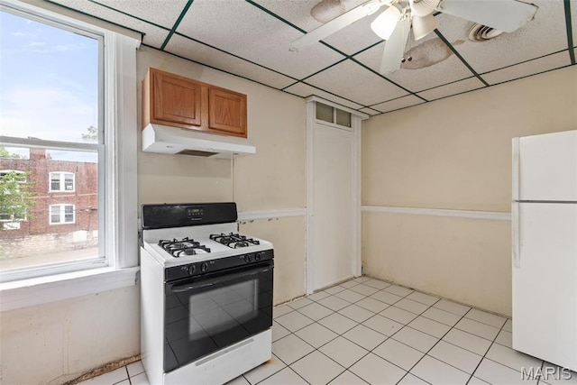 3456 Miami St, Saint Louis, MO 63118 - kitchen with gas stove, freestanding refrigerator, under cabinet range hood, brown cabinets, and a drop ceiling