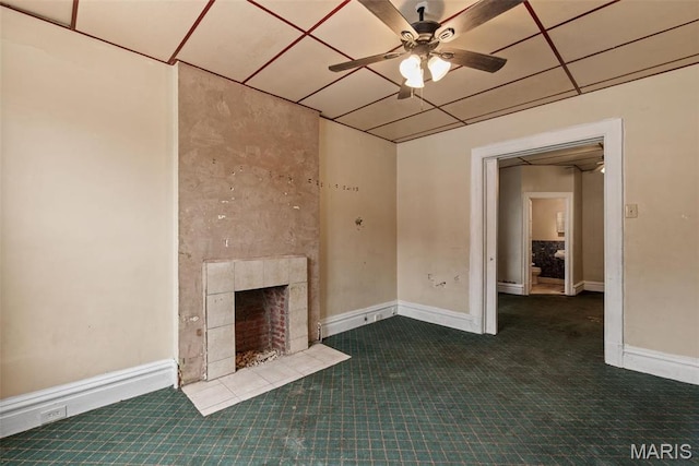 3456 Miami St, Saint Louis, MO 63118 - unfurnished living room featuring a ceiling fan, carpet, a tiled fireplace, and baseboards