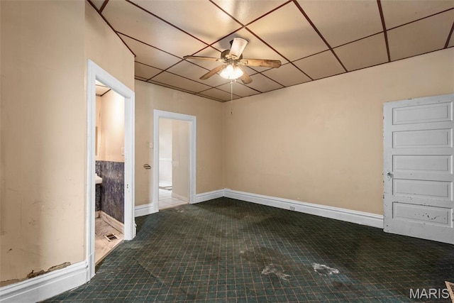 3456 Miami St, Saint Louis, MO 63118 - empty room featuring ceiling fan, baseboards, a drop ceiling, and dark tile patterned floors
