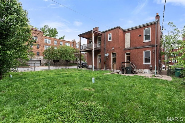 3456 Miami St, Saint Louis, MO 63118 - rear view of property featuring a balcony, a chimney, brick siding, and a yard