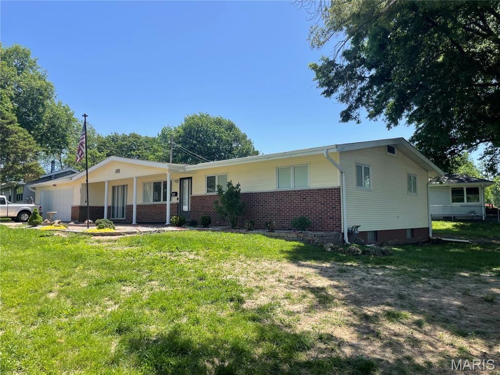 single story home with a garage, brick siding, and a front yard