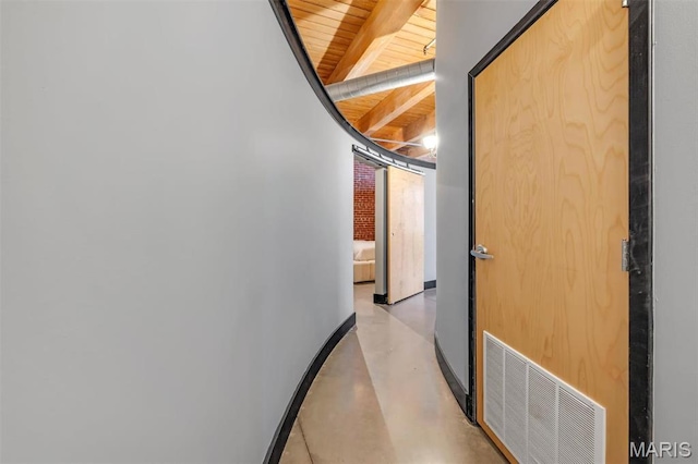 corridor featuring wooden ceiling, concrete floors, baseboards, and beam ceiling
