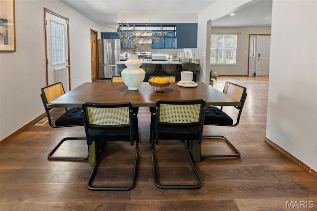 dining space featuring baseboards and wood finished floors