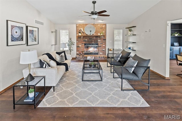 living area with plenty of natural light, lofted ceiling, ceiling fan, wood finished floors, and baseboards