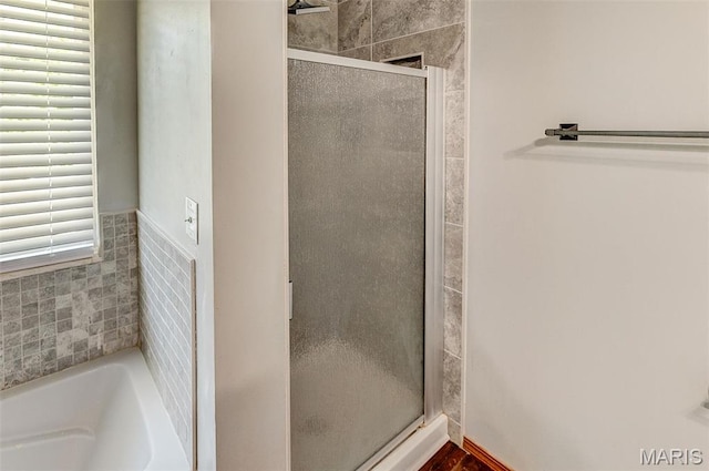 full bath featuring a stall shower and a garden tub