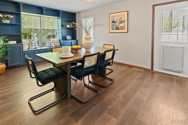 dining space with plenty of natural light, wood finished floors, and baseboards