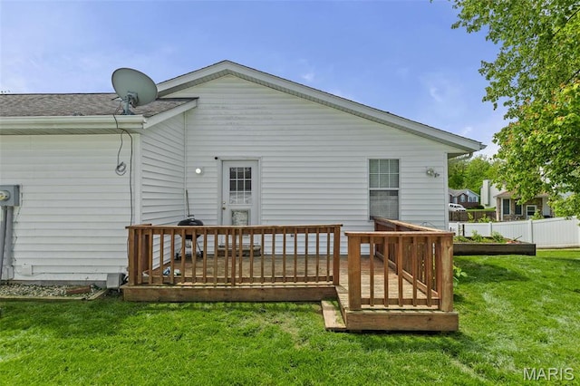 back of property featuring a yard, a deck, and a shingled roof