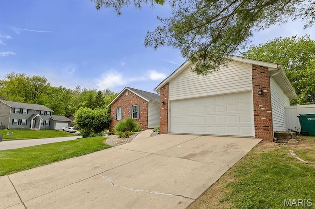 view of front of home with brick siding, concrete driveway, and a front lawn