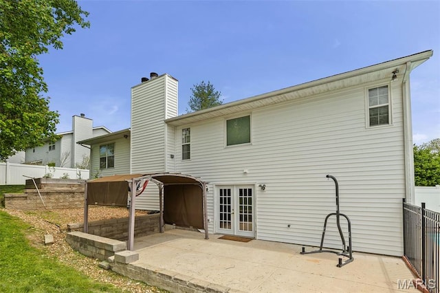 back of house with french doors, a patio area, a chimney, and fence