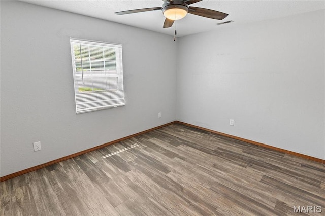 spare room with ceiling fan, wood finished floors, and baseboards