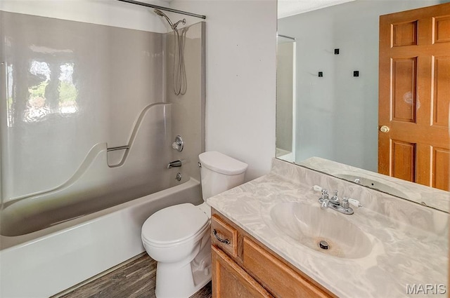 full bathroom with toilet, wood finished floors, vanity, and  shower combination