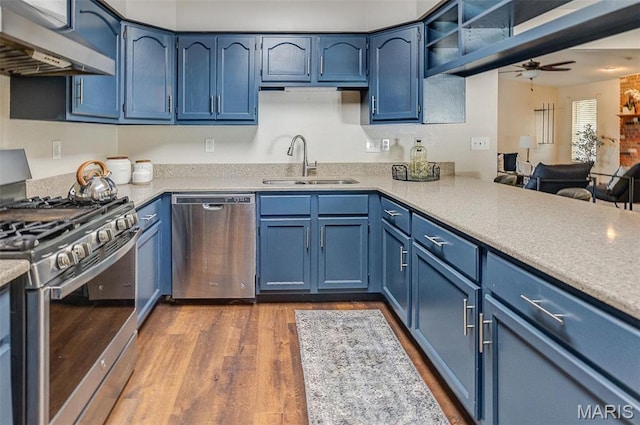 kitchen featuring stainless steel appliances, a sink, and blue cabinetry