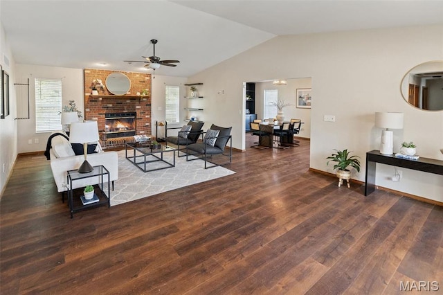 living room featuring ceiling fan, plenty of natural light, wood finished floors, lofted ceiling, and a fireplace