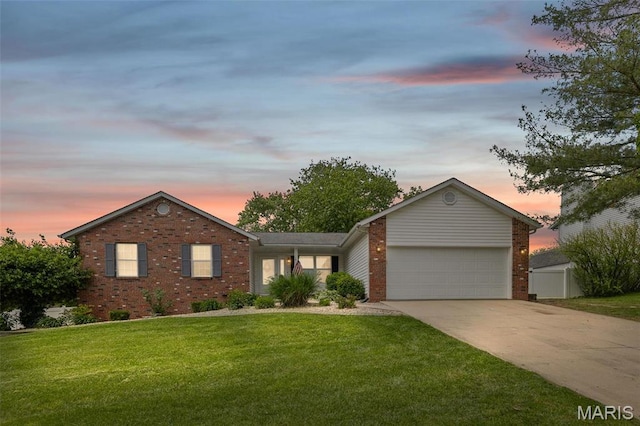 view of front facade with brick siding, an attached garage, a lawn, and driveway