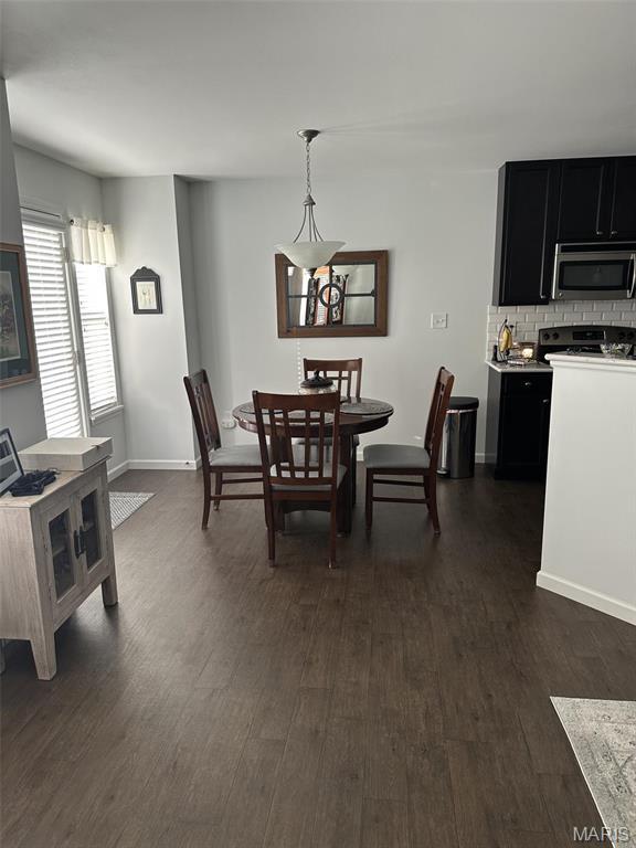1805 Hyland Green Dr, Ofallon, MO 63366 - dining room with dark wood-style floors and baseboards