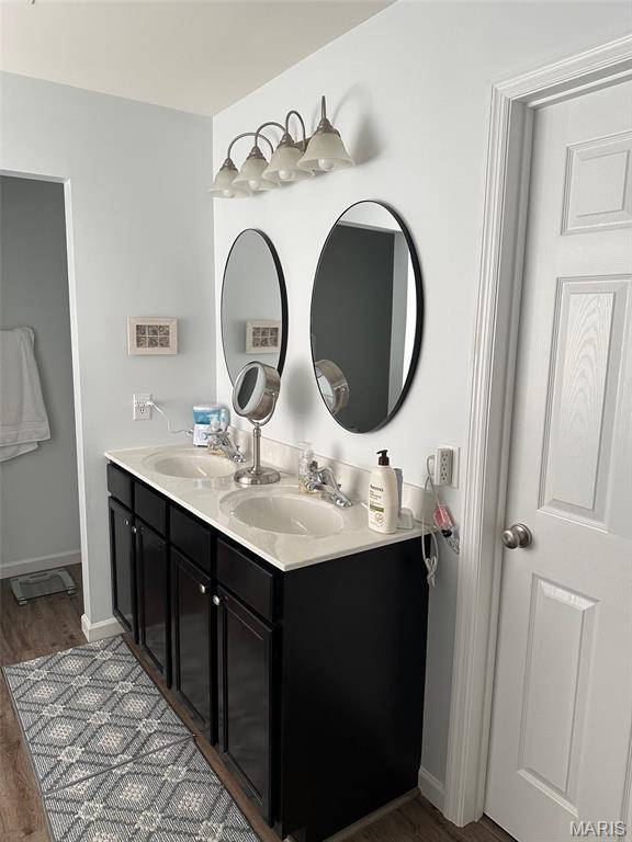 1805 Hyland Green Dr, Ofallon, MO 63366 - bathroom featuring wood finished floors, double vanity, and baseboards