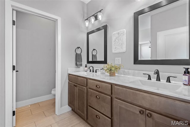 136 Oakshire Dr, Troy, IL 62294 - full bathroom with wood finished floors, toilet, double vanity, and baseboards