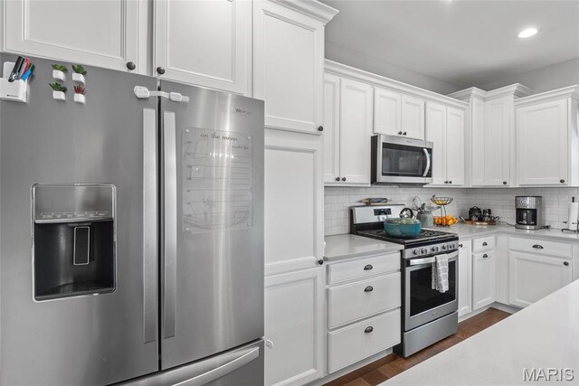 136 Oakshire Dr, Troy, IL 62294 - kitchen with appliances with stainless steel finishes, light countertops, white cabinets, backsplash, and dark wood-style floors