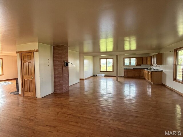 29595 State Highway 3, La Plata, MO 63549 - unfurnished living room featuring dark wood-style flooring, plenty of natural light, and a sink
