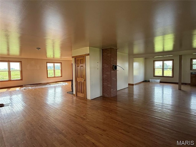 29595 State Highway 3, La Plata, MO 63549 - unfurnished living room featuring wood finished floors, healthy amount of natural light, and baseboards