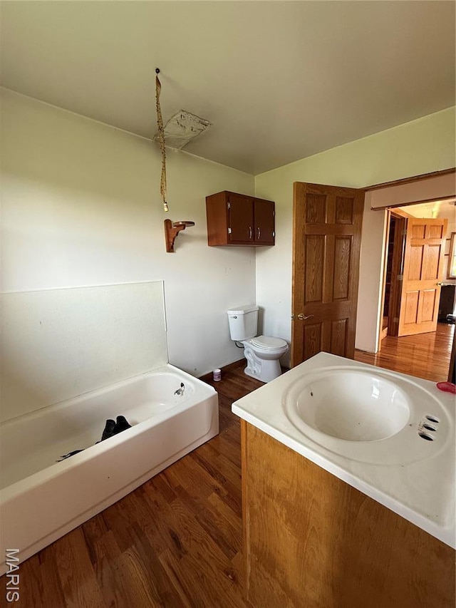 29595 State Highway 3, La Plata, MO 63549 - bathroom featuring a tub to relax in, wood finished floors, toilet, and vanity