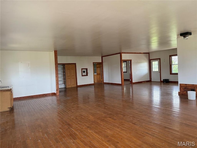 29595 State Highway 3, La Plata, MO 63549 - unfurnished living room featuring dark wood-style flooring, baseboards, and a sink