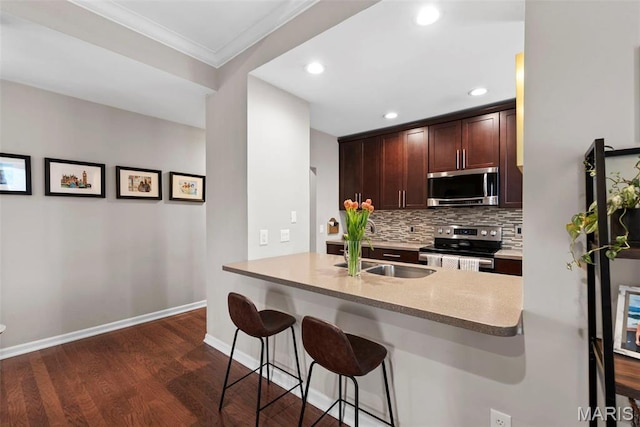 4260 Lindell Blvd Unit B, Saint Louis, MO 63108 - kitchen featuring stainless steel appliances, a sink, dark wood-type flooring, a kitchen bar, and tasteful backsplash