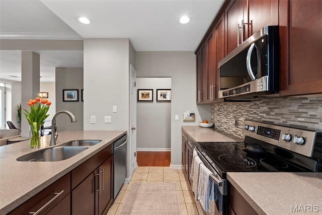 4260 Lindell Blvd Unit B, Saint Louis, MO 63108 - kitchen featuring appliances with stainless steel finishes, a sink, decorative backsplash, baseboards, and light countertops