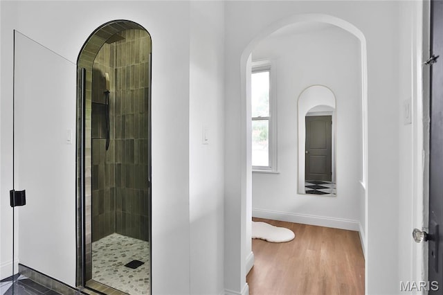 6504 Michigan Ave, Saint Louis, MO 63111 - bathroom with tiled shower, baseboards, and wood finished floors