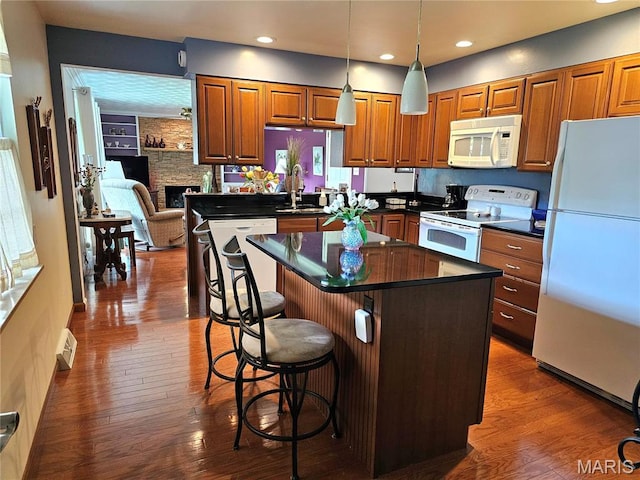 1117 Meadow Ln, Sparta, IL 62286 - kitchen with white appliances, dark countertops, a center island, dark wood-style flooring, and brown cabinets