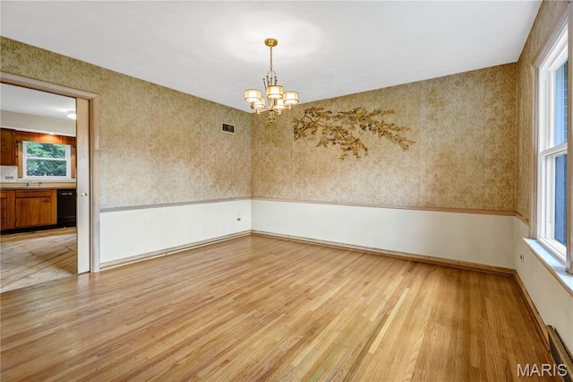 369 Halcyon Dr, Saint Louis, MO 63122 - empty room featuring light wood-style flooring, a chandelier, plenty of natural light, and wallpapered walls
