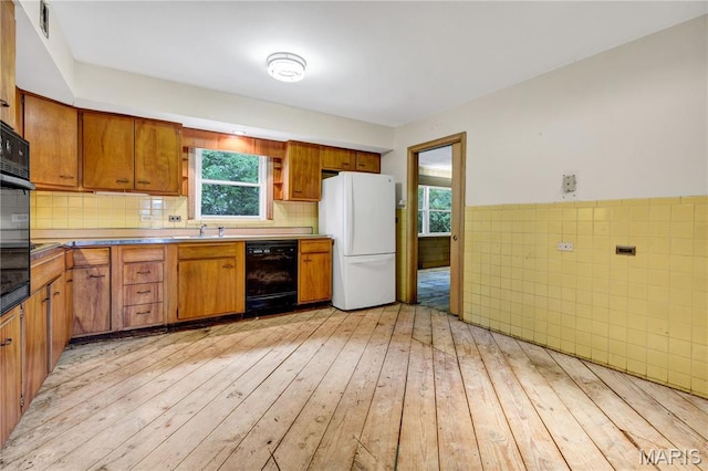 369 Halcyon Dr, Saint Louis, MO 63122 - kitchen featuring freestanding refrigerator, black dishwasher, light wood-style floors, brown cabinets, and tile walls
