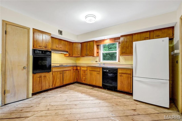 369 Halcyon Dr, Saint Louis, MO 63122 - kitchen featuring black appliances, light wood finished floors, brown cabinetry, and tasteful backsplash