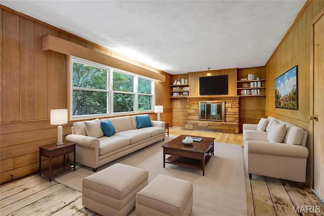 369 Halcyon Dr, Saint Louis, MO 63122 - living area featuring light wood-type flooring, wood walls, built in features, and a stone fireplace