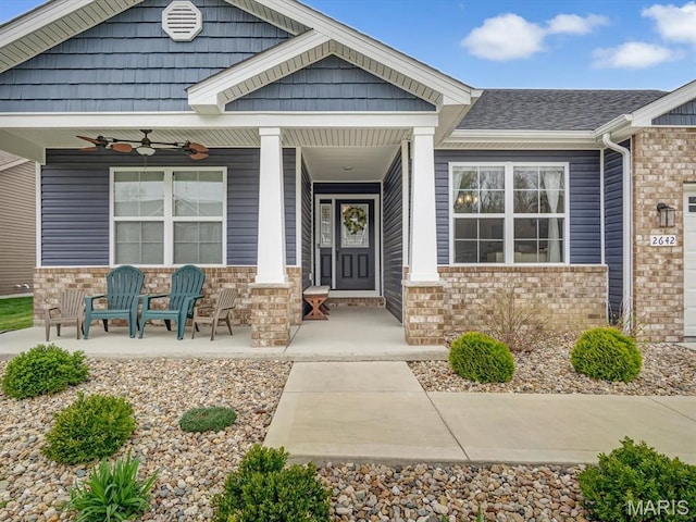 property entrance featuring a porch, a ceiling fan, and brick siding