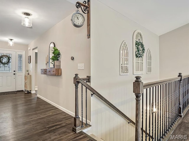 corridor featuring an upstairs landing, wood finished floors, and baseboards