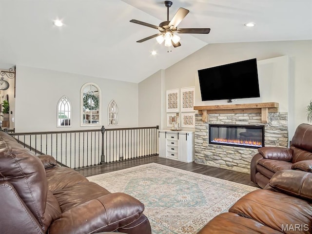living room with ceiling fan, wood finished floors, lofted ceiling, a stone fireplace, and recessed lighting