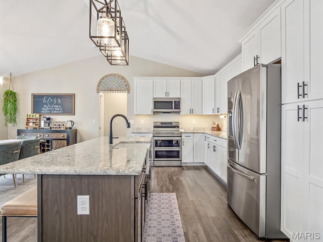 kitchen featuring stainless steel appliances, lofted ceiling, dark wood finished floors, and white cabinetry