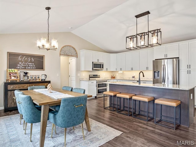 dining area featuring a chandelier, vaulted ceiling, and dark wood finished floors