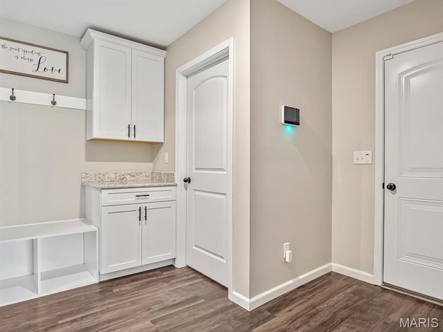 mudroom featuring dark wood finished floors and baseboards