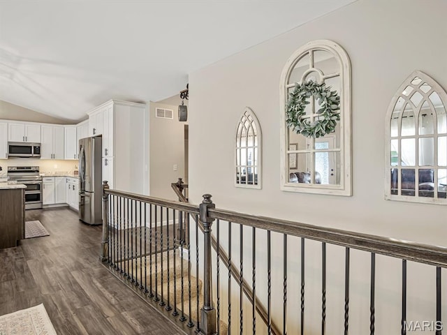 corridor featuring lofted ceiling, an upstairs landing, and dark wood-style floors