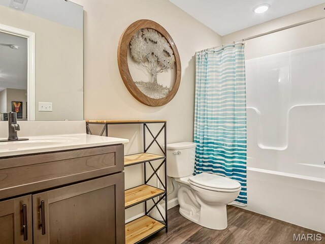 full bath featuring wood finished floors, toilet, vanity, and shower / bath combo