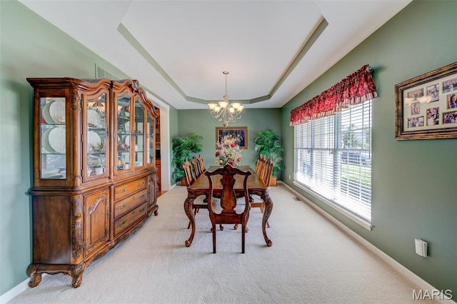 41 Deer Creek Dr, Ofallon, MO 63366 - dining area with a chandelier, a tray ceiling, light carpet, and baseboards