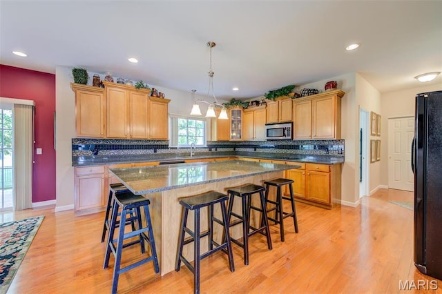41 Deer Creek Dr, Ofallon, MO 63366 - kitchen featuring freestanding refrigerator, stainless steel microwave, light wood-style floors, a sink, and recessed lighting