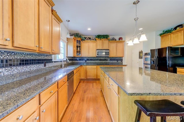 41 Deer Creek Dr, Ofallon, MO 63366 - kitchen featuring black appliances, light wood-style flooring, a sink, backsplash, and glass insert cabinets